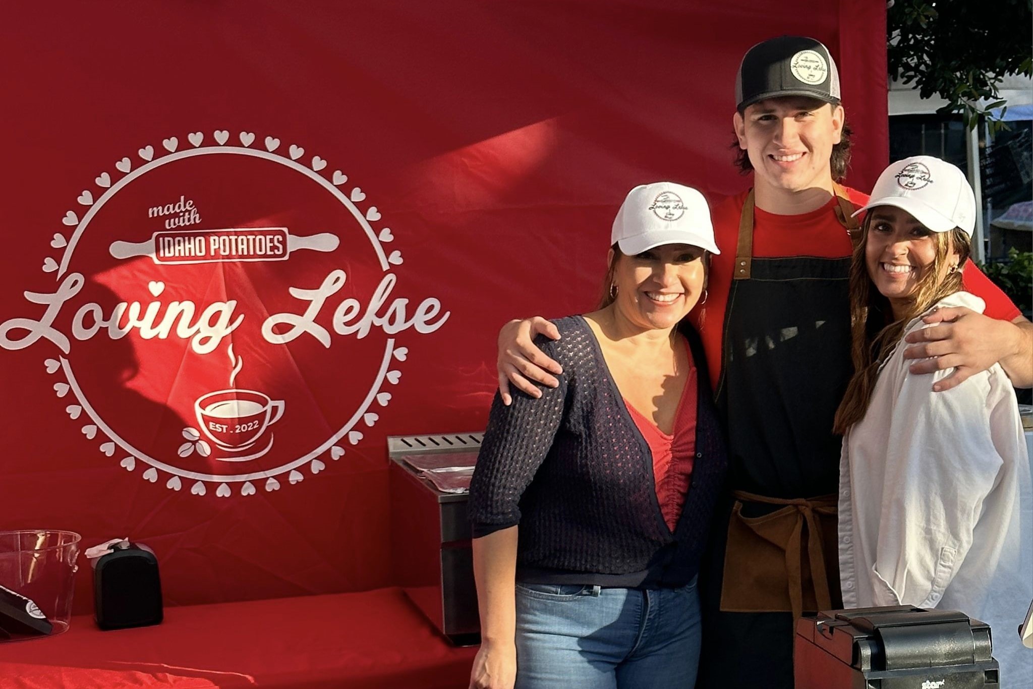 Three people in front of a banner.