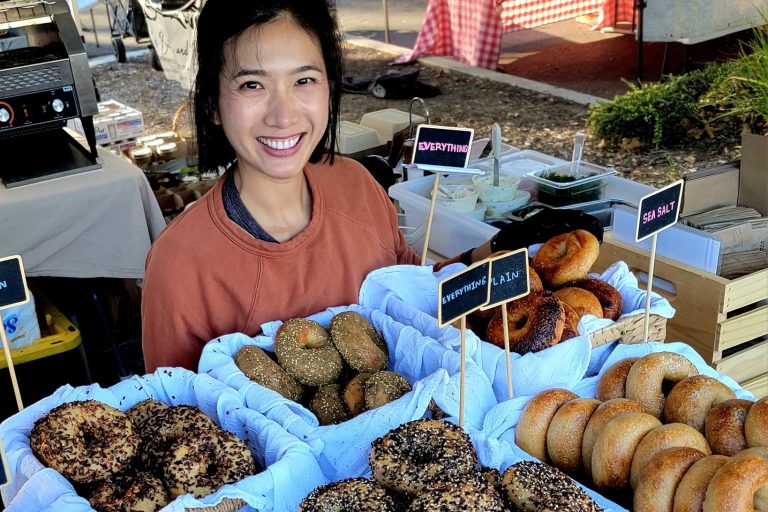 Women with a table of bagels.